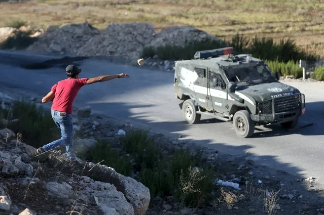 A Palestinian throws a stone at Israeli police vehicle during a protest against Israeli police raid on Jerusalem's al-Aqsa mosque, near Israel's Ofer Prison near the occupied West Bank city of Ramallah September 17, 2015. Saudi Arabia denounced on Thursday what it called violations by Israeli forces of Jerusalem's al-Aqsa mosque, one of Islam's holiest sites, which has seen days of clashes between Israeli police and stone-throwing Palestinians. (Photo by Mohamad Torokman/Reuters)