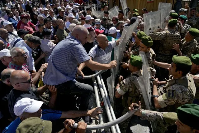 Soldiers scuffle with retired army members as they try to enter to the parliament building while the legislature was in session discussing the 2022 budget, during a protest in downtown Beirut, Lebanon, Monday, September 26, 2022. The protesters demanded an increase in their monthly retirement pay, decimated during the economic meltdown. (Photo by Bilal Hussein/AP Photo)
