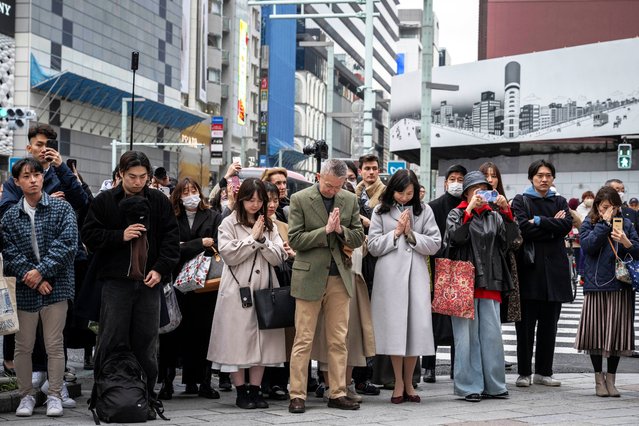 People pray as they take part in a minute of silence to remember the victims on the 14th anniversary of the 2011 earthquake, tsunami and nuclear disaster, in the Ginza shopping district of Tokyo on March 11, 2025. (Photo by Yuichi Yamazaki/AFP Photo)