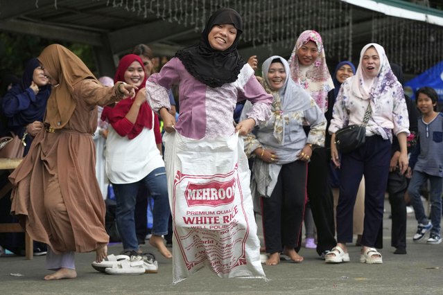 Muslim women react during a sack race as they celebrate Eid al-Fitr at a park in Quezon City, Philippines, March 31, 2025. (Photo by Aaron Favila/AP Photo)