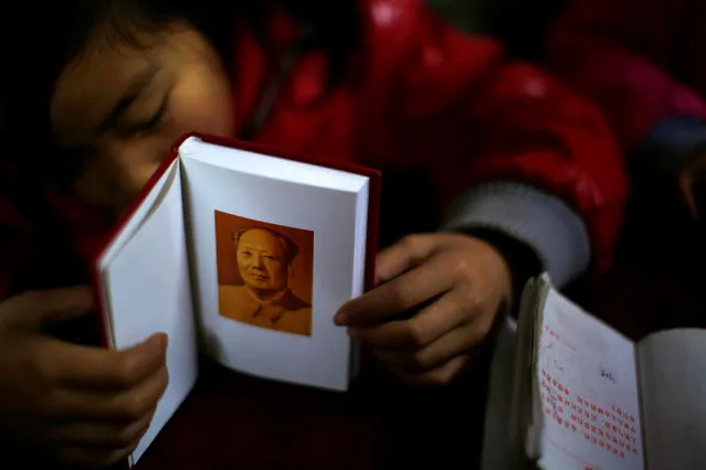 A student falls asleep as she holds a book containing a portrait of China's late chairman Mao Zedong during a lesson at the Democracy Elementary and Middle School in Sitong town, Henan province December 3, 2013. (Photo by Carlos Barria/Reuters)
