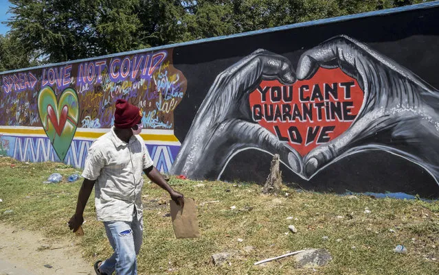A man walks past an informational mural about the coronavirus painted on the outside walls of the Coast General Hospital in the coastal city of Mombasa, Kenya, Monday, August 17, 2020. (Photo by AP Photo/Stringer)