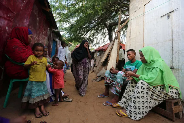 Somali couple Mohamed Noor and Huda Omar sit with their family in front of their home in Mogadishu's Rajo camp, Somalia August 30, 2016. (Photo by Feisal Omar/Reuters)