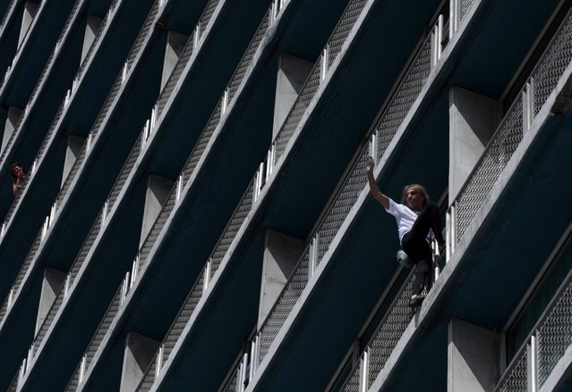 Alain Robert of France, who is known as "Spiderman", waves during his climb up the Habana Libre hotel in Havana February 4, 2013. Robert, who scales buildings all over the world without safety equipment, successfully climbed the hotel which is 126 metres (413 feet) high.  REUTERS/Stringer (CUBA - Tags: SOCIETY)