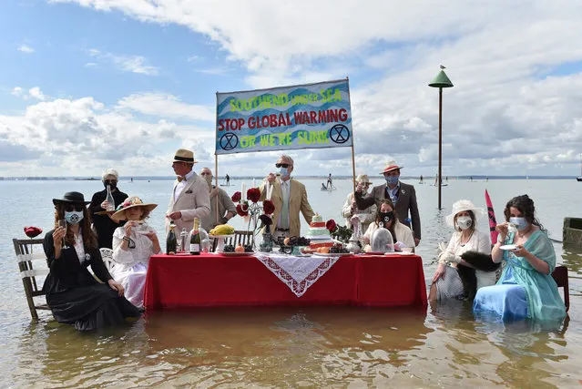 Extinction Rebellion protesters stage a Titanic-themed dinner party in the sea to illustrate the threat of rising sea levels, on Chalkwell beach on August 31, 2020 in Southend-on-Sea, England. Due to the coronavirus pandemic, Extinction Rebellion protesters have been encouraged to take action locally against the airports, the fossil fuel industry and petrol stations and banks ahead of larger-scale demonstrations planned for London, Manchester and Cardiff on September 1. (Photo by John Keeble/Getty Images)