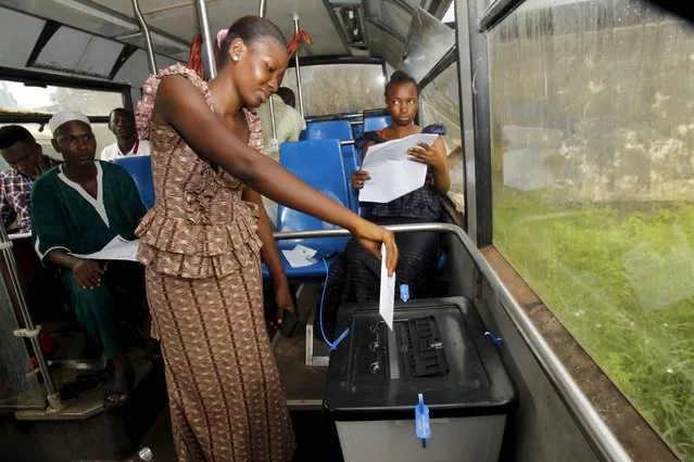 A woman casts her vote in an old bus which is used as a polling station during a presidential election in Conakry, Guinea October 11, 2015. Long lines formed in front of guarded polling booths across Guinea on Sunday as the West African country voted in its second free election in nearly 60 years since independence. (Photo by Luc Gnago/Reuters)