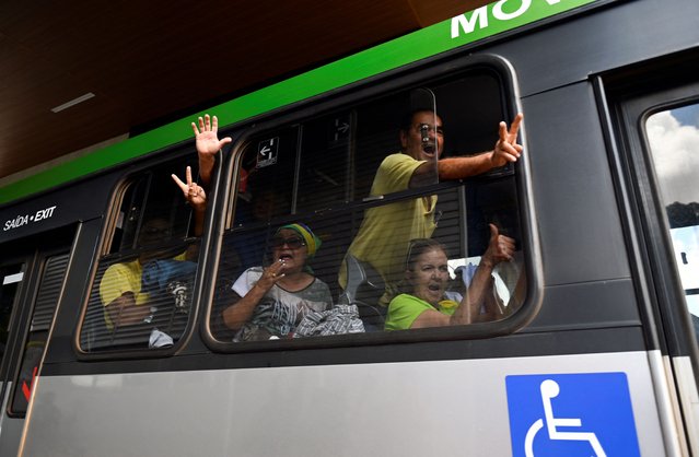 A samll group of supporters of Brazil's far-right ex-president Jair Bolsonaro who had been arrested after they invaded the Congress, presidential palace and Supreme Court, gesture from inside a bus while leaving the Federal Police headquarters in Brasilia, on January 10, 2023. Brazilian security forces cleared protest camps on the eve and arrested 1,500 people as President Luiz Inacio Lula da Silva condemned “acts of terrorism” after a far-right mob stormed the seat of power, unleashing chaos on the capital. Hardline Bolsonaro supporters have been protesting outside army bases calling for a military intervention to stop Lula from taking power since his election win. (Photo by Mauro Pimentel/AFP Photo)