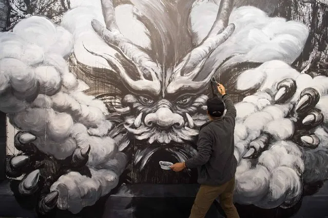 Chinese artist Qi Xinghua works at his painting for the exhibition “Magic City” in Dresden, eastern Germany, on September 22, 2016. The exhibition “Magic City – The Art Of The Street” featuring 40 street artist runs from October 1, 2016 to January 8, 2017. (Photo by Sebastian Kahnert/AFP Photo)
