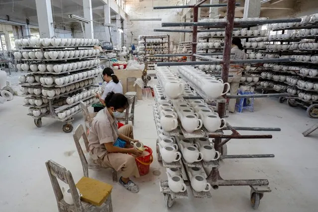 Labourers work on ceramic products at an assembly of Hai Duong ceramic factory in Hải Dương province, Vietnam on July 24, 2020. (Photo by Kham via Reuters)