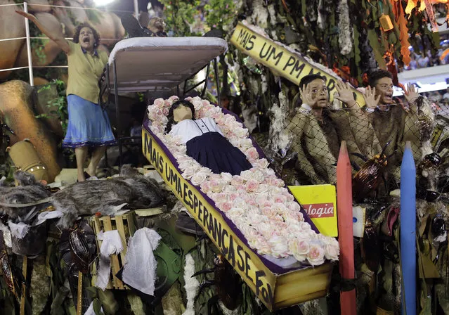 Members from the Beija Flor samba school perform showing a coffin containing a doll representing a dead student during Carnival celebrations at the Sambadrome in Rio de Janeiro Brazil, Tuesday, February 13, 2018. (Photo by Silvia Izquierdo/AP Photo)