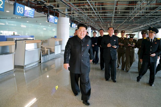 North Korean leader Kim Jong Un (front) smiles as he gives field guidance at the construction site of Terminal 2 of Pyongyang International Airport, which is nearing completion, in this undated photo released by North Korea's Korean Central News Agency (KCNA) in Pyongyang April 12, 2015. (Photo by Reuters/KCNA)
