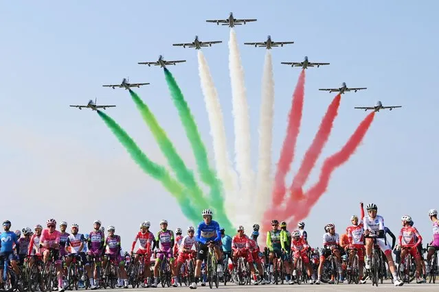 The pack of cyclists is backdropped by the Frecce Tricolori Italian Air Force aerobatic squad flying past, prior to the 15th stage of the Giro d'Italia cycling race, Italy, at the Rivolto air base, Sunday, October 18, 2020. (Photo by Gian Mattia D'Alberto/LaPresse via AP Photo)