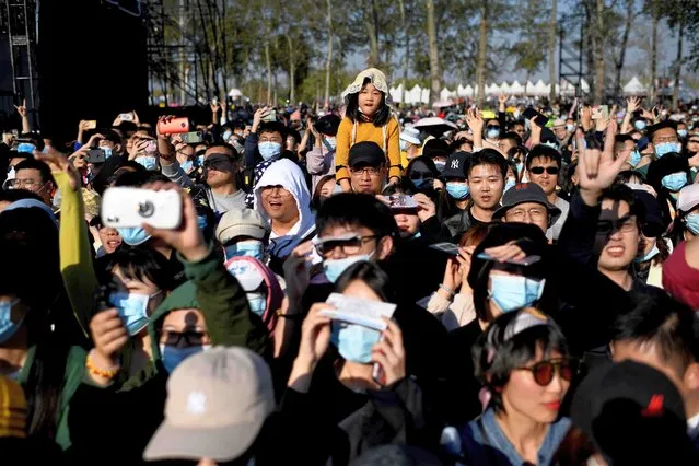 A young girl (C) sits on someone's shoulders to see over people wearing face masks as they attend the two-day Rye Music Festival in Beijing on October 18, 2020. (Photo by Noel Celis/AFP Photo)