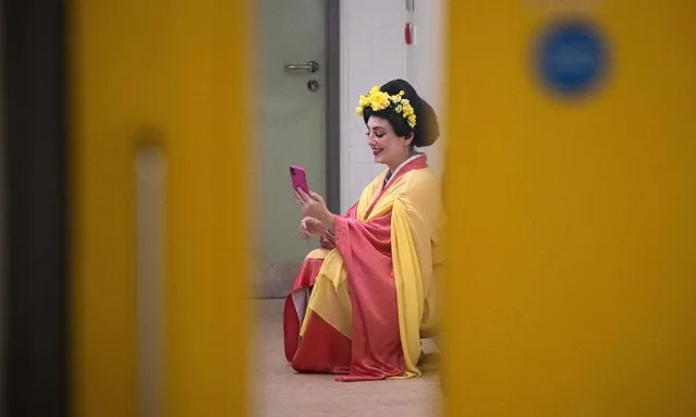 A member of Ukraine's Dnipro Opera, speaks on her phone backstage during the interval of a performance of Giacomo Puccini's opera Madama Butterfly in Scarborough Spa theatre in Scarborough, north-east England, on February 22, 2023. In 1974 the refurbished Opera and Ballet Theatre in Dnipropetrovsk, now Dnipro, reopened and the modern-day Dnipro Opera was formed. Now in its 49th season, the Opera continues to perform in Dnipro and has also embarked on a two month tour of the UK performing Madama Butterfly, Carmen and Aida. (Photo by Oli Scarff/AFP Photo) 