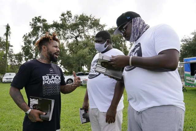 Phillip Agnew, left, a leader of Black Men Build, speaks to Derrick Williams, right, and Davion Frazier at a “Free the Vote” rally to the polls, Saturday, October 24, 2020, in Miami. Get out the vote efforts targeting Black men aren’t just about persuading them to choose former Vice President Joe Biden over incumbent Donald Trump.  “We are not choosing a champion, we are choosing an opponent”, says activist Agnew. (Photo by Marta Lavandier/AP Photo)