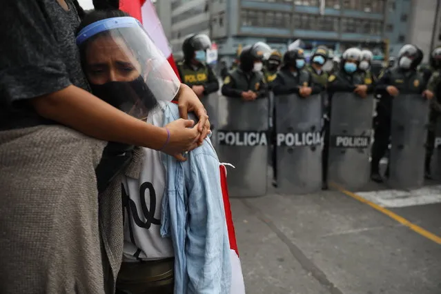 Alejandra Rodriguez is embraced by her sister Luciana as police block them and other supporters of former President Martin Vizcarra from reaching Congress where lawmakers voted the previous night to remove Vizcarra from office in Lima, Peru, Tuesday, November 10, 2020. (Photo by Rodrigo Abd/AP Photo)