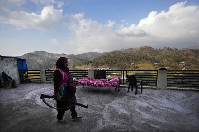Village Defense Group member Usha Raina holding a gun stands on the rooftop of her house at Kalal Khas Village, in Rajouri, India, February 7, 2023. Days after seven Hindus were killed in the village in disputed Kashmir,  Indian authorities revived a government-sponsored militia and began rearming and training villagers. The militia, officially called the “Village Defense Group”, was initially formed in the 1990s as the first line of defense against anti-India insurgents in remote villages that government forces could not reach quickly. (Photo by Channi Anand/AP Photo)