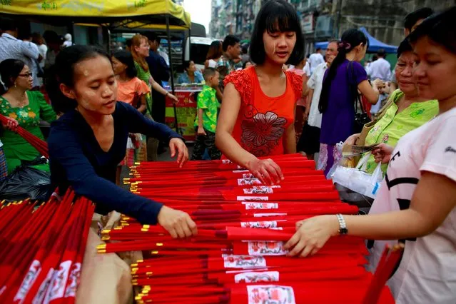 Myanmar Chinese women sell incenses sticks during a festival dedicated to Buddhist monk Shin Upagutta, celebrated by Myanmar's ethnic Chinese community, in Chinatown in Yangon October 21, 2015. (Photo by Soe Zeya Tun/Reuters)