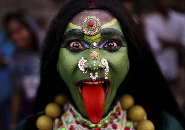 A man dressed as the Hindu Goddess Kali participates in a religious procession as part of the “Ram Navami” festival in New Delhi, India, on April 19, 2013. Ram Navami celebrates the birthday of Hindu god Rama. (Photo by Kevin Frayer/Associated Press)