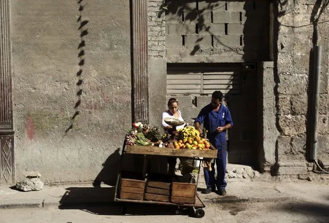 A woman buys fruit from a street cart in Havana December 17, 2014. (Photo by Reuters/Stringer)