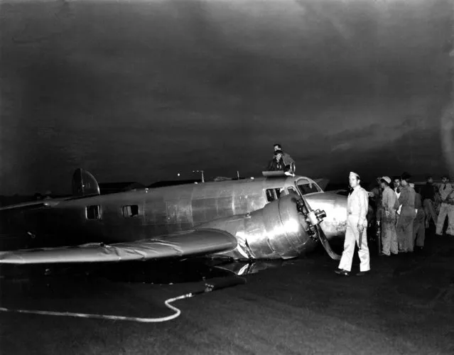 American aviatrix Amelia Earhart, navigator Frederick Noonan, standing behind her, and Capt. Harry Manning emerge from the Electra after it crashed on takeoff from Luke Field, near Pearl Harbor, Hawaii, March 20, 1937.  Earhart and her crew were en route to Howard Island on their around-the-world flight. The smashed propeller and motor are visible in foreground. (Photo by AP Photo)