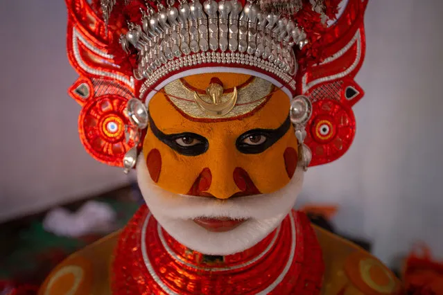 A man dressed in the likeness of the Hindu deity Muthappan waits to perform during the Theyyam ritualistic dance festival on March 13, 2023 in Somwarpet, India. Theyyam is a colourful socioreligious dance form that is the amalgamation of ritual, vocal and instrumental music, dance, painting, and literature and its genesis can be traced to the coastal regions of the southern Indian states of Kerala and Karnataka. (Photo by Abhishek Chinnappa/Getty Images)