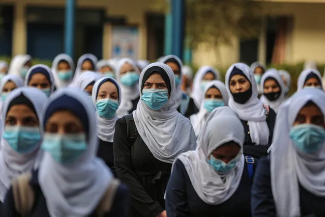 Senior high school students, wearing face masks, wait in line before their lessons as they begin face-to-face education after a break as part of the novel coronavirus (COVID-19) pandemic, at the school yard in Gaza City, Gaza on October 26, 2020. (Photo by Ali Jadallah/Anadolu Agency via Getty Images)