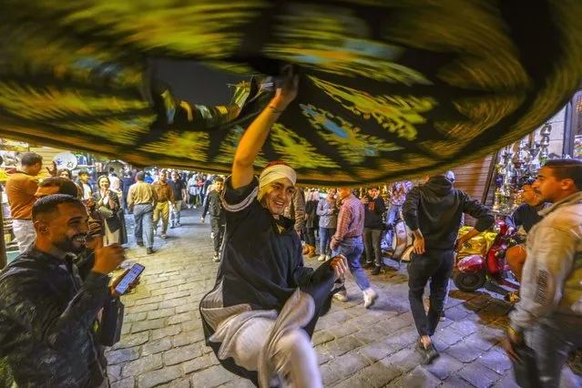 A whirling dervish spins during a traditional performance during the holy month of Ramadan at Al Muezz Street in Cairo, Egypt, late Tuesday, April 4, 2023. (Photo by Amr Nabil/AP Photo)