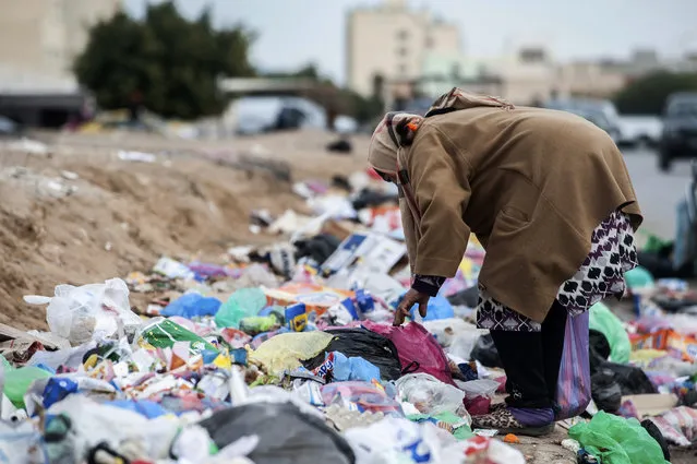 A woman picks through garbage in Kasserine, Tunisia, on Friday December 11, 2020. Hundreds of desperate Tunisians have set themselves on fire over the past 10 years to protest police harassment, poverty or the lack of opportunity in the country. They are following the example of 26-year-old fruit seller Mohammed Bouazizi, whose self-immolation in 2010 led to the downfall of Tunisia’s dictator of 23 years. (Photo by Riadh Dridi/AP Photo)