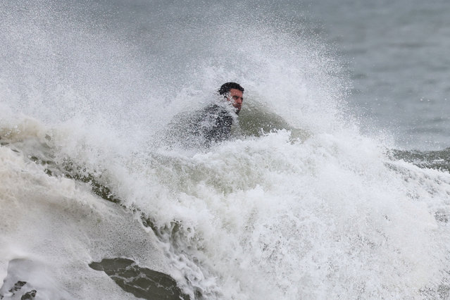 A man surfs during Hurricane Erin in Long Beach, New York, on August 21, 2025. New York City Mayor Eric Adams ordered all city public beaches – including Coney Island and Brighton Beach - to close Wednesday and Thursday. (Photo by Shannon Stapleton/Reuters)