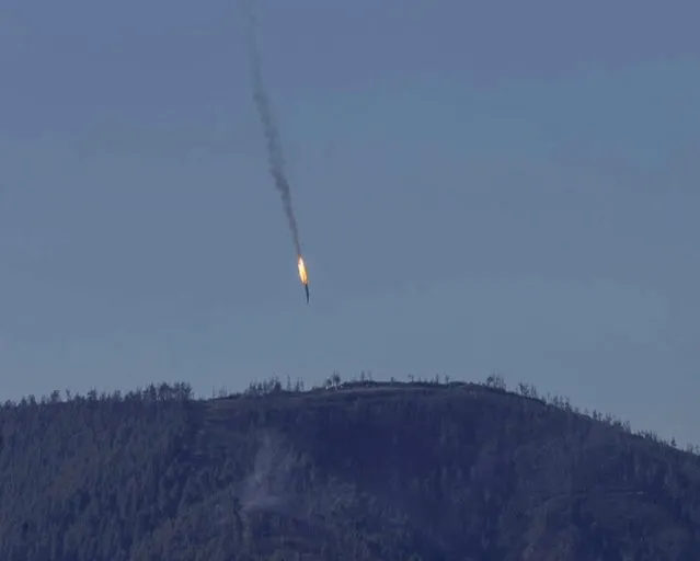 A still image made available on 24 November 2015 from video footage shown by the HaberTurk TV Channel shows a burning trail as a plane comes down after being shot down near the Turkish-Syrian border, over north Syria, 24 November 2015. (Photo by EPA/Haberturk TV Channel)