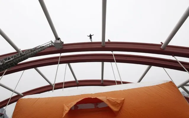 A man jumps off from the top of a bridge as he attempts to commit suicide, in Liuzhou, Guangxi Zhuang Autonomous Region January 9, 2015. (Photo by Reuters/Stringer)