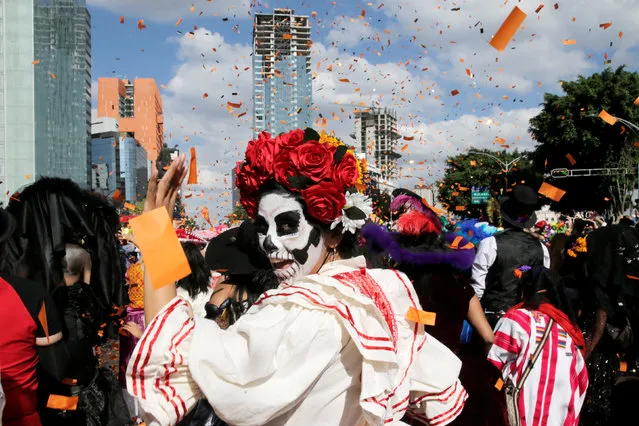 A woman with her face painted as a skull or "Catrina" participates in the “Day of the Dead” parade in Mexico City, Mexico, October 29, 2016. (Photo by Carlos Jasso/Reuters)