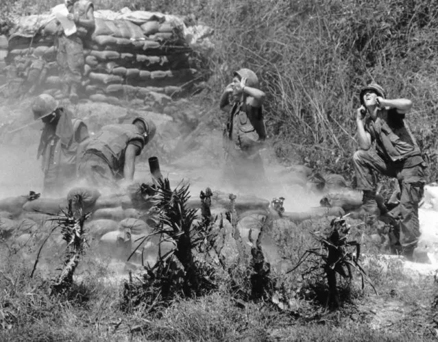A U.S. Marine mortar crew fires a salvo at a suspected enemy position during a sweep of the Hoa Valley, Southeast of Da Nang in South Vietnam on May 18, 1969. The marines are attached to the 5th Regiment of the 1st Marine Division. (Photo by Hugh Van Es/AP Photo)