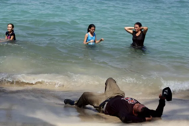 A family of Cuban migrants relaxes by the sea after arriving safely into La Miel in the province of Guna Yula, having crossed the border from Colombia through the jungle November 26, 2015. Scores of Cubans have come to shore at a remote outpost in Panama near the Colombian border as they seek overland passage towards the United States fearing a recent detente between Washington and Havana could end their preferential treatment. (Photo by Carlos Jasso/Reuters)