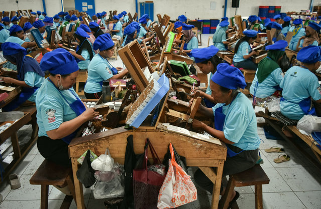 Thousands of workers make the hand-rolled kretek cigarettes at a factory in Malang, East Java, Indonesia, on November 17, 20225.They receive a wage of USD 1,79 per 1,000 sticks. (Photo by Aman Rochman/ZUMA Press Wire/Rex Features/Shutterstock)