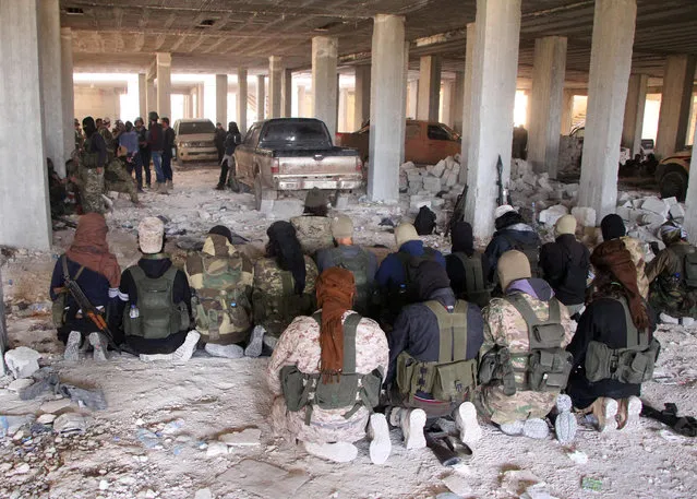 Rebel fighters from the Jaish al-Fatah (or Army of Conquest) brigades pray inside a building on November 3, 2016, at an entrance to Aleppo, in the southwestern frontline near the neighbourhood of Dahiyet al-Assad, during a rebel offensive to break a three-month siege of the opposition-held east of Syria's second city. Syrian rebels launched a new wave of car bombs and rockets on Aleppo's western districts, redoubling their efforts to break the government's three-month siege of the city. (Photo by Omar Haj Kadour/AFP Photo)