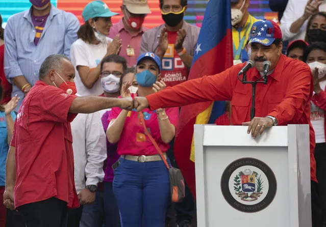 Diosdado Cabello, a candidate for Monagas state for the Great Patriotic Pole party in the upcoming National Assembly elections, left, bump fists with Venezuela's President Nicolas Maduro during a closing campaign rally in Caracas, Venezuela, Thursday, December 3, 2020. Venezuelans will vote for a new National Assembly on Sunday, Dec 6. (Photo by Ariana Cubillos/AP Photo)