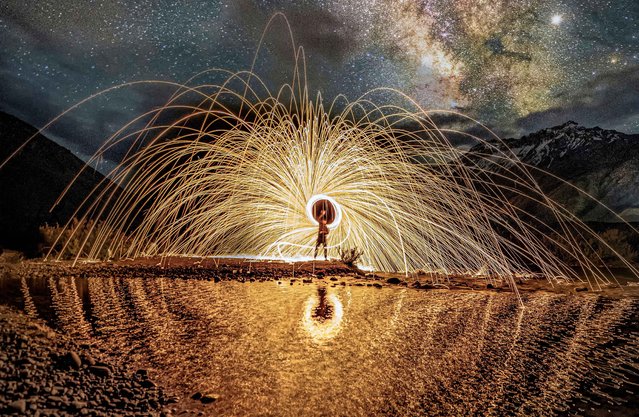 Sparks fly in front of the Milky Way in Himachal Pradesh, India on May 12, 2023.  Lit steel wool is spun in front of the stunning cluster of stars and over a pool of water. The scene was pictured in the Himalayas, by using a 30 second exposure to capture the stars and movement of sparks. (Photo by Ganesh Bagal/Solent News/Rex Features/Shutterstock)
