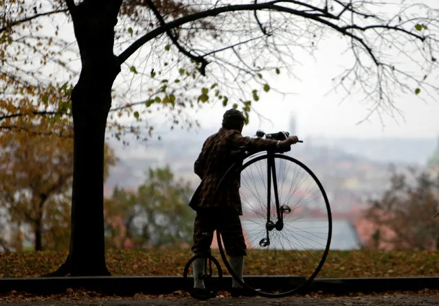 A man wearing a historical costume pushes his high-wheel bicycle before the annual penny farthing race in Prague, Czech Republic November 5, 2016. (Photo by David W. Cerny/Reuters)