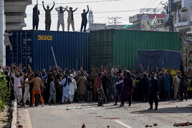 Activists of the Tehreek-e-Labbaik Pakistan (TLP) party protest after authorities blocked the road with shipping containers in Lahore on October 10, 2025, ahead of their pro-Palestinian march towards Islamabad. (Photo by Arif Ali/AFP Photo)