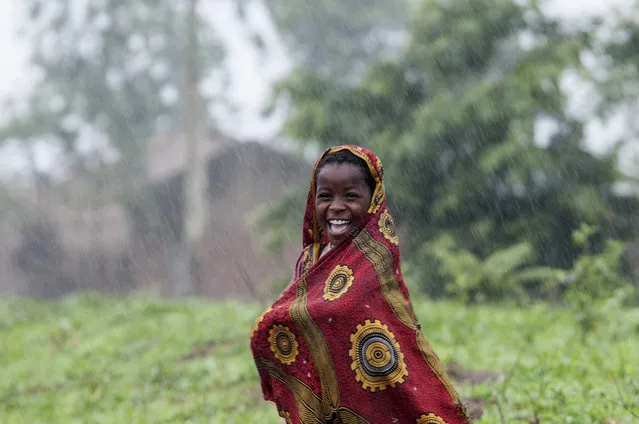 A Malawian school child smiles as she walks in the rain in Chiradzulou, southern Malawi, Thursday, January 22, 2015. Malawi has been affected by flooding caused by heavy rains, with scores of people having died and some 200,000 displaced. (Photo by Shiraaz Mohamed/AP Photo)