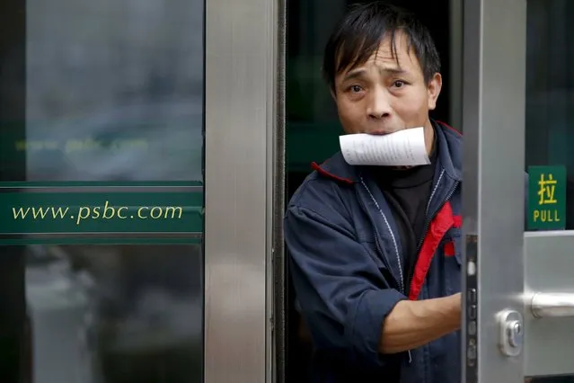 A man holding a receipt from an ATM machine in his mouth walks out of a branch of Postal Savings Bank of China (PSBC) in downtown Beijing, China, in this November 12, 2015 file photo. China's Postal Savings Bank said it had raised $7 billion from a 17 percent stake sale that attracted 10 strategic investors, including UBS Group AG and JPMorgan ahead of an initial public offering planned for next year. (Photo by Kim Kyung-Hoon/Reuters)