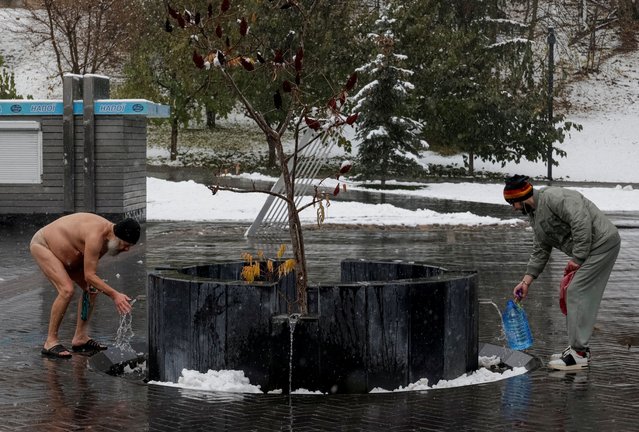 Residents are seen near city well during the first snowfall, amid Russia's attack on Ukraine, in Kharkiv, Ukraine on November 14, 2024. (Photo by Sofiia Gatilova/Reuters)