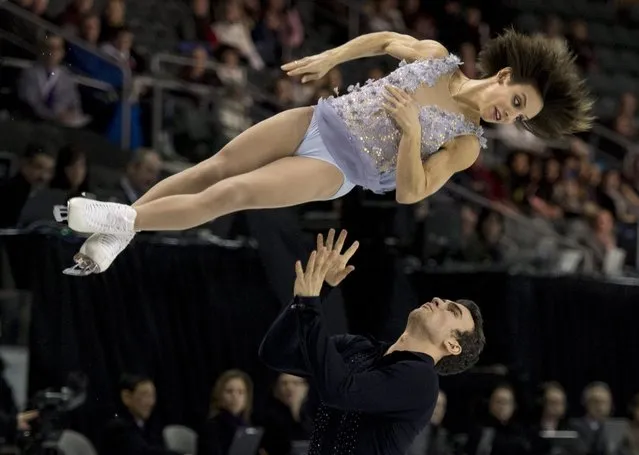 Meagan Duhamel, top, is thrown by her partner Eric Radford as they perform their short program in the pairs competition at the Canadian Figure Skating Championships, Friday, January 23, 2015, in Kingston, Ontario. (Photo by Paul Chiasson/AP Photo/The Canadian Press)