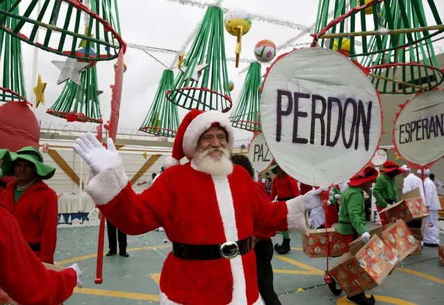 A Spanish inmate dressed as Santa Claus holds a sign that says “forgiveness” during a Christmas event at Sarita Colonia male prison in Callao, Peru, December 18, 2015. (Photo by Mariana Bazo/Reuters)