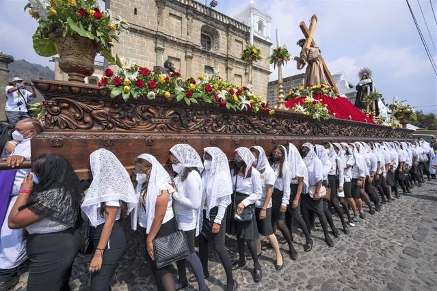 Women carry a statue of Jesus Christ on a religious float during a Holy Thursday procession, in Antigua, Guatemala, Thursday, April 14, 2022. (Photo by Moises Castillo/AP Photo)