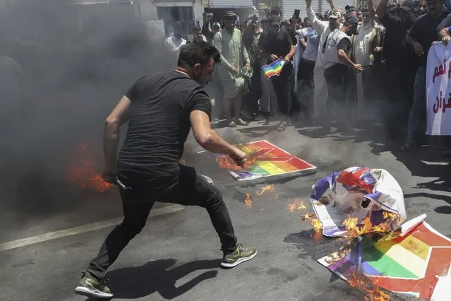 Supporters of Shiite Muslim leader Moqtada Sadr burn a rainbow flag, in response to the burning of a copy of the Quran in Sweden, during open-air Friday prayers in Basra, Iraq, Friday, June 30, 2023. (Photo by Nabil al-Jurani/AP Photo)