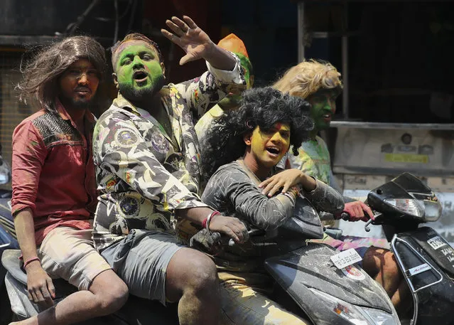 Youth, with their faces smeared with colored powder, ride on motor bikes during Holi festivities in Hyderabad, India, Monday, March 29, 2021. (Photo by Mahesh Kumar A.)/AP Photo