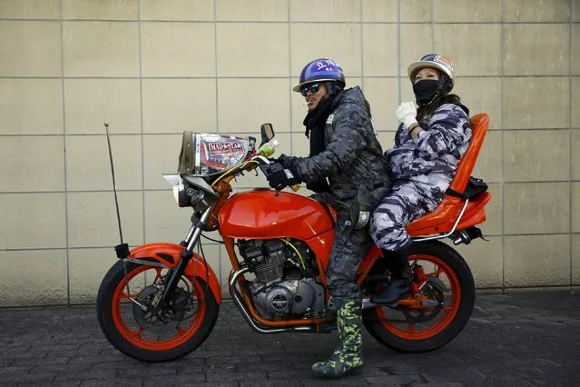 A man and a woman pose on a Bousouzoku motorbike at the Dangouzaka rest stop in Yamanashi, west of Tokyo, Japan, January 3, 2016. (Photo by Thomas Peter/Reuters)